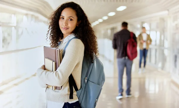 Im off to class. Cropped portrait of an attractive young female college student standing with her textbooks in a campus hallway. — 스톡 사진