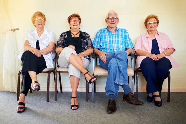Esperando a nuestros nietos. Fotografía de un grupo de ancianos alegres sonriendo y posando para la cámara dentro de un edificio. —  Fotos de Stock