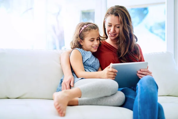 Eksploracja online. Przycięte zdjęcie matki i córki korzystających z tabletu cyfrowego razem w domu. — Zdjęcie stockowe