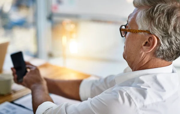 I think this flu is affecting my eyesight. Shot of a mature businessman struggling to use his cellphone in the office. —  Fotos de Stock