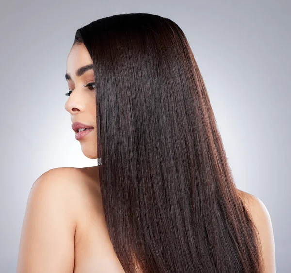 Every strand perfectly on point. Studio shot of an attractive young woman posing against a grey background. — ストック写真