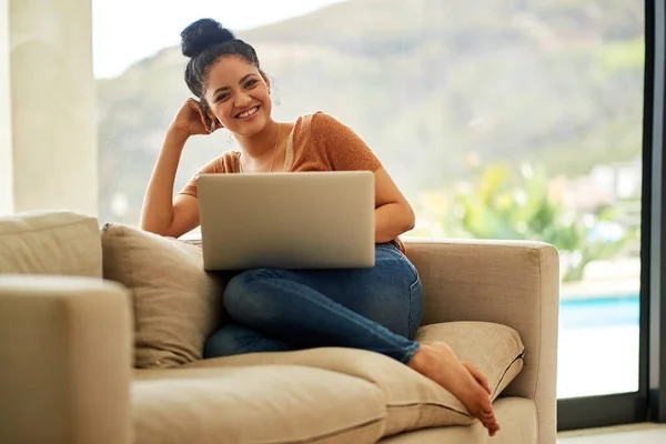 So comfy and convenient. Shot of a beautiful young woman using a laptop at home. — 스톡 사진