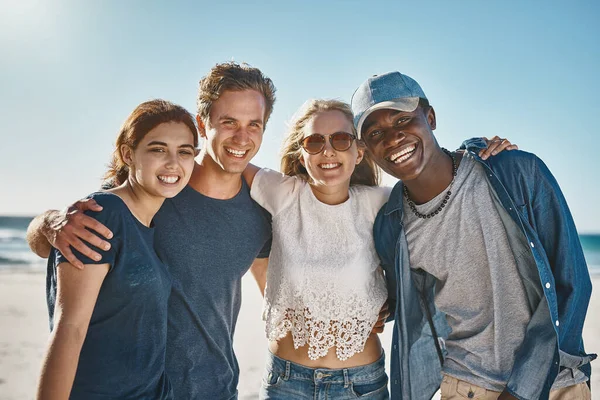 Brought together by their love of the beach. Portrait of a group of happy young friends posing on the beach together. — Foto de Stock