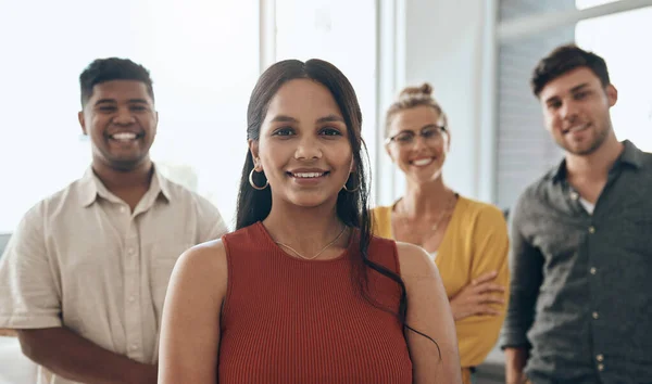 Sono dalla mia parte. Ritratto di una giovane donna d'affari in piedi in un ufficio con i suoi colleghi sullo sfondo. — Foto Stock