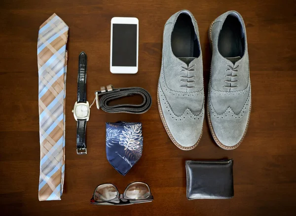 Veste-te para o sucesso. Tiro de ângulo alto de uma roupa de negócios elegante e acessórios postos em uma mesa. — Fotografia de Stock