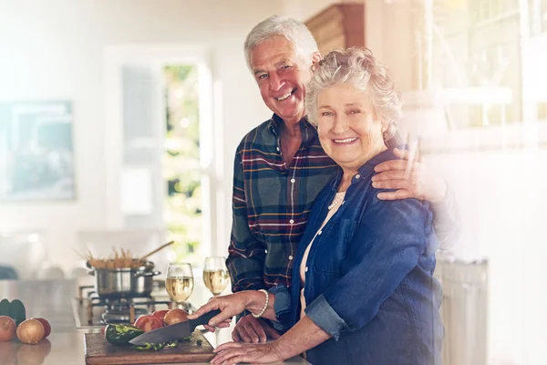 Cinta musim direndam dalam kepedulian, rasa hormat dan kepercayaan. Potret pasangan senior memasak bersama di dapur mereka di rumah. — Stok Foto