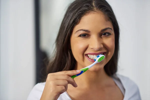 Fresh breath requires daily maintenance. Shot of an attractive young woman getting ready in her bathroom. — Stock Photo, Image