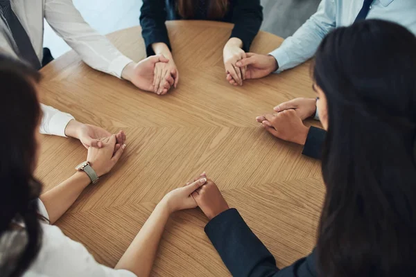 Μερικές φορές οι συνάδελφοί μας είναι η μεγαλύτερη πηγή υποστήριξής μας. Τραβηγμένο πλάνο μιας ομάδας επιχειρηματιών που κάθονται μαζί σε ένα τραπέζι και κρατιούνται χέρι χέρι. — Φωτογραφία Αρχείου