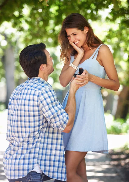 Gör mig till den lyckligaste mannen en ung man som knäböjer i parken och friar till sin flickvän.. — Stockfoto