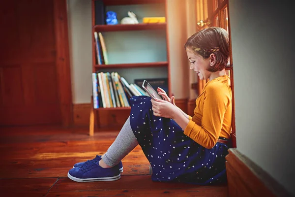 Jugando todos sus juegos favoritos. Fotografía de una niña usando una tableta digital en casa. —  Fotos de Stock