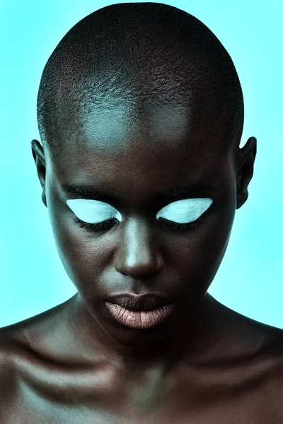 A beleza é daltônica. Uma bela mulher posando contra um fundo azul néon. — Fotografia de Stock