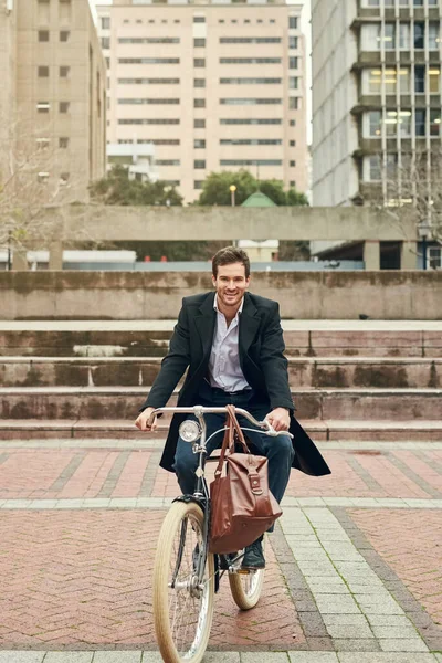 Педалирование через город больших возможностей. Портрет молодого бизнесмена, едущего на работу на велосипеде. — стоковое фото