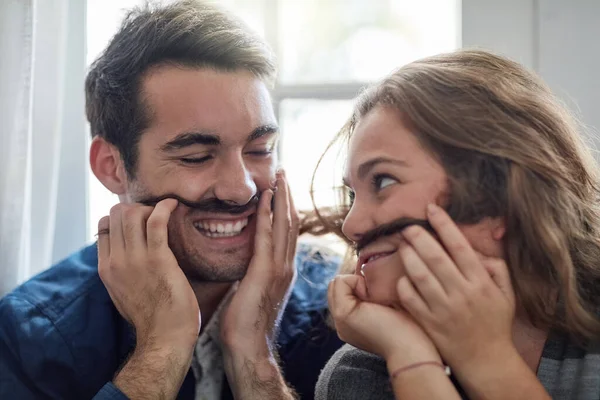 Não nos levamos muito a sério. Tiro de um jovem casal desfrutando de um momento bobo juntos enquanto relaxa em casa. — Fotografia de Stock