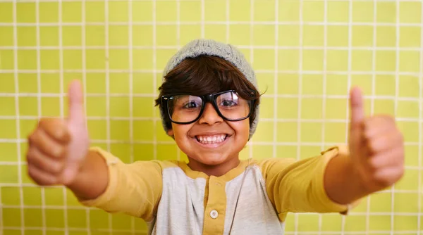 Von den Kindern gut angenommen. Aufnahme eines niedlichen kleinen Jungen mit Brille und einer Mütze, die Daumen nach oben zeigt. — Stockfoto