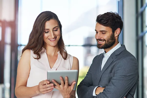 Slimme leidinggevenden gebruiken slimme technologie. Foto van een jonge zakenman en zakenvrouw die samen een digitale tablet gebruiken in een kantoor. — Stockfoto