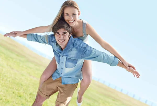 Ahhhhh, young love. A playful young couple enjoying a beautiful day in the outdoors. — Stock Photo, Image