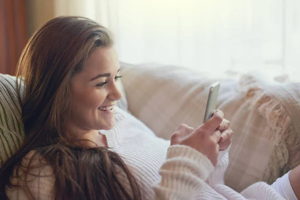 Alle Geschäfte haben sich am Wochenende angemeldet. Aufnahme einer schönen jungen Frau beim SMS-Schreiben auf ihrem Handy zu Hause. — Stockfoto