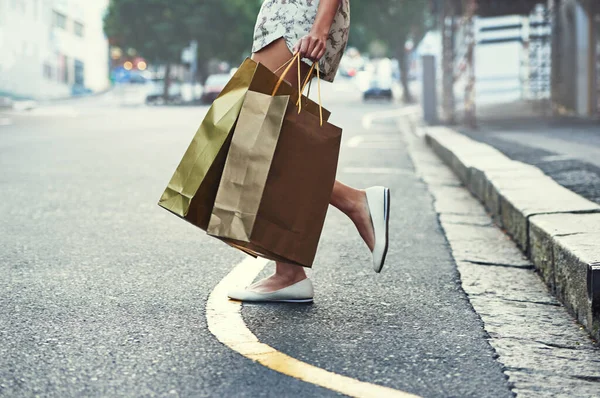 Fare shopping e 'il suo cardio. Colpo ritagliato di una donna con borse della spesa che attraversano una strada della città. — Foto Stock