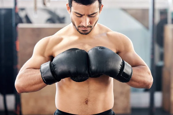 Keskittyminen ja päättäväisyys. Ammuttu komea nuori nyrkkeilijä harjoittelee jabia kuntosalilla. — kuvapankkivalokuva