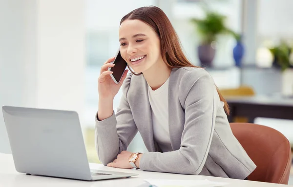 Concéntrate en ser productivo en lugar de ocupado. Fotografía de una mujer joven usando su teléfono y portátil en una oficina. — Foto de Stock