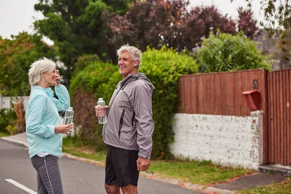 Hicimos nuestro ejercicio por hoy. Recortado disparo de una alegre pareja de ancianos beber agua después de tener un trote juntos fuera en un suburbio. — Foto de Stock