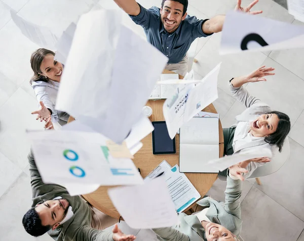 One positive thought can change your whole day. Aerial shot of a diverse group of businesspeople throwing paperwork in the air in celebration while in the office. — 스톡 사진