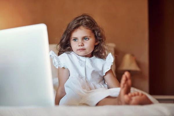 A recuperare i suoi cartoni animati preferiti. Girato di una adorabile bambina che guarda qualcosa su un computer portatile a casa. — Foto Stock