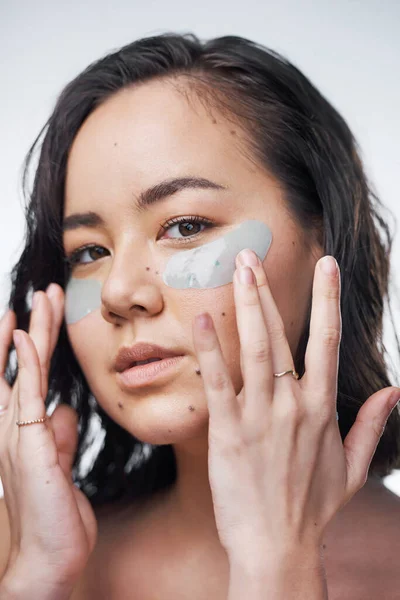 Zeep en water is gewoon niet genoeg. Studio shot van een mooie jonge vrouw dragen under-eye patches. — Stockfoto