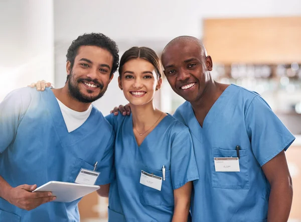 그 들은 젊지만 경험이 있다. 명랑 한 젊은 의사들 이 병원 안에 있는 디지탈 태블릿을 들고 함께 서 있는 모습. — 스톡 사진