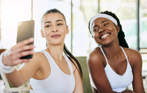 Bem, toma outro depois de recebermos o troféu. Tiro recortado de duas jovens jogadoras de tênis atraentes tirando selfies em seu clube. — Fotografia de Stock