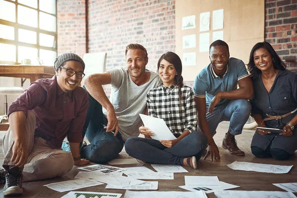 Allein sind wir ein Tropfen, gemeinsam sind wir ein Ozean. Aufnahme eines Teams von Unternehmern, die zusammenarbeiten und in einem modernen Büro auf dem Boden sitzen. — Stockfoto