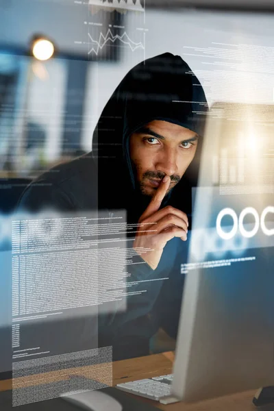 You didnt see anything. Portrait of a serious computer hacker hacking into a computer in an office. — ストック写真