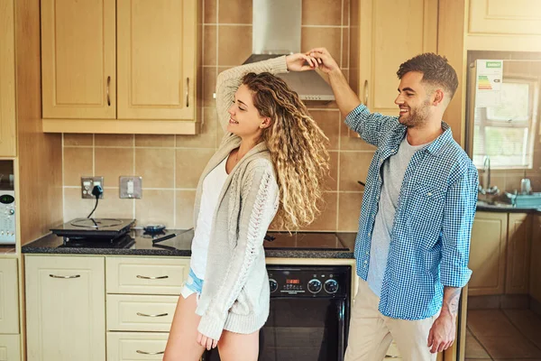 He spins my world around. Shot of a young couple dancing in the kitchen at home. —  Fotos de Stock