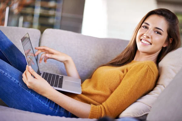 Tylko ja i mój laptop. Ujęcie atrakcyjnej młodej kobiety relaksującej się na kanapie z laptopem. — Zdjęcie stockowe