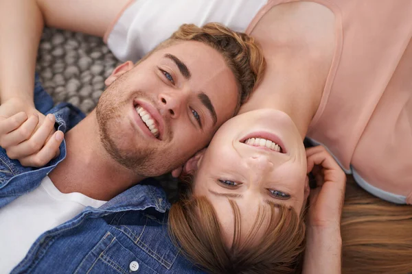 Blissful giovane amore. Una giovane coppia sdraiata sul pavimento del soggiorno vicino insieme con affetto. — Foto Stock