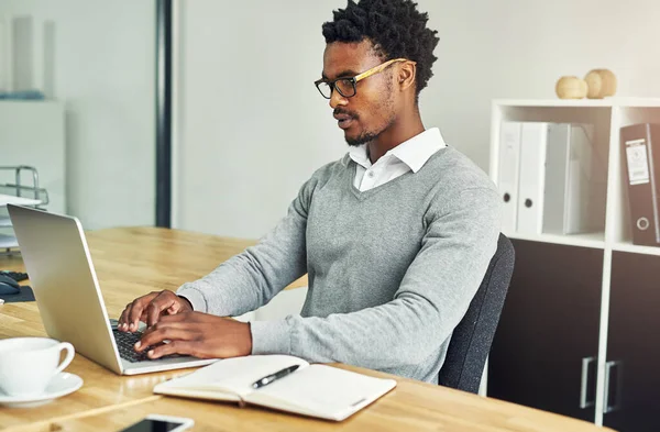 Rispondendo ad alcune email. Foto ritagliata di un giovane uomo d'affari che lavora su un computer portatile in un ufficio moderno. — Foto Stock