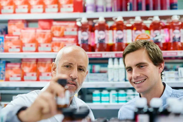 We only recommend the best to you. Shot of a pharmacist assisting a customer in a chemist. —  Fotos de Stock