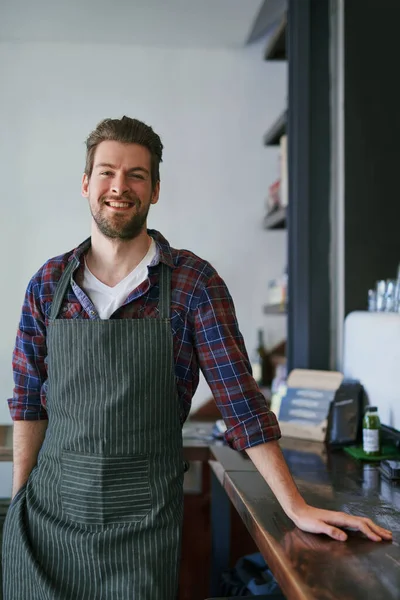 Servimos apenas o melhor café. Retrato recortado de um jovem de pé em seu café. — Fotografia de Stock