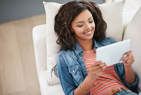 Godere di internet e di tutta la sua libertà. Colpo ad angolo alto di una giovane donna che usa il suo tablet digitale a casa. — Foto Stock