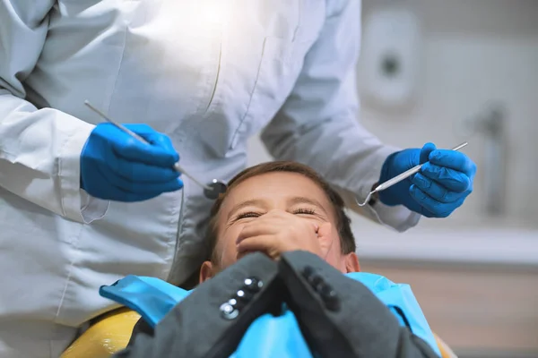 Ho tanta paura di aprire bocca. Ha sparato a un ragazzino spaventato sdraiato su una sedia da dentista e tiene la bocca chiusa per impedire al dentista di lavorare su di lui.. — Foto Stock