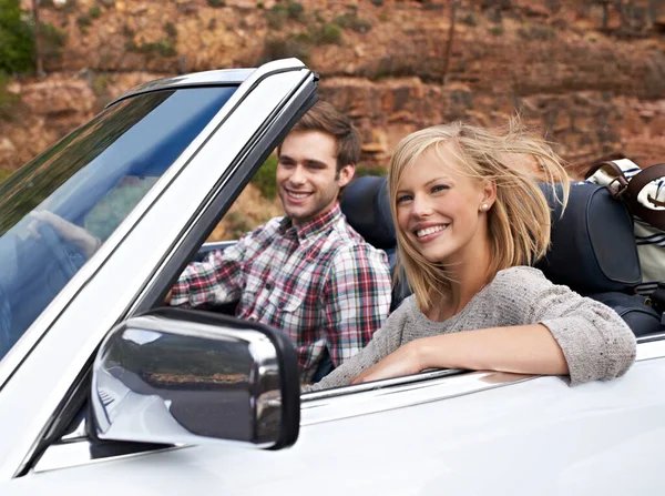 We love our weekend getaways. Shot of a young couple enjoying a drive in a convertible. — Stock Photo, Image