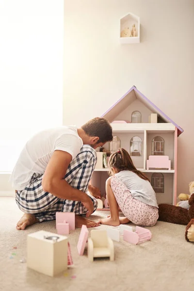 Ele faz o que ela quer. Filmagem completa de um jovem bonito e sua filha brincando com sua casa de bonecas. — Fotografia de Stock