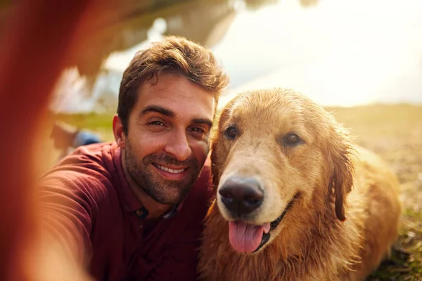 Gülümse, evlat. Yakışıklı bir delikanlıyla köpeğinin parkta selfie çekerken çekilmiş bir fotoğrafı.. — Stok fotoğraf