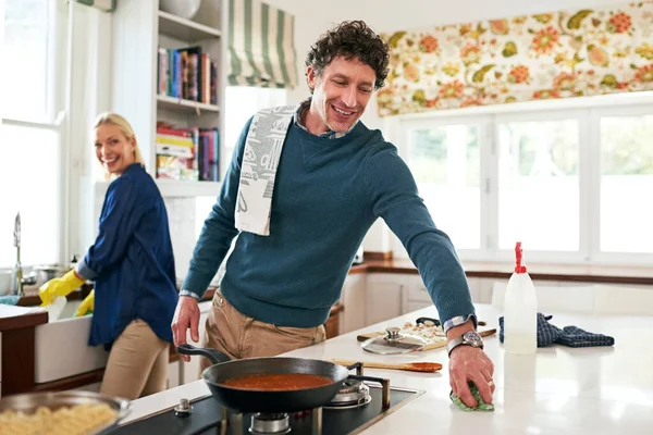 A preparar a limpeza pós-jantar. Tiro de um casal feliz limpando sua cozinha juntos depois de cozinhar o jantar. — Fotografia de Stock