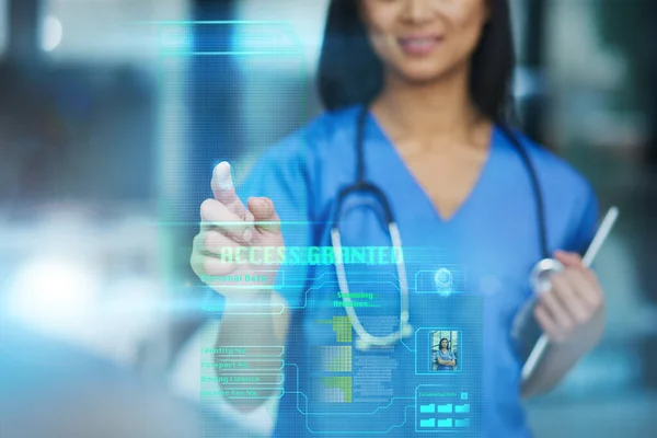 Nowa technologia prowadzi do postępu medycznego. Przycięte ujęcie nierozpoznawalnej pielęgniarki korzystającej z ekranu dotykowego podczas stania w szpitalu. — Zdjęcie stockowe