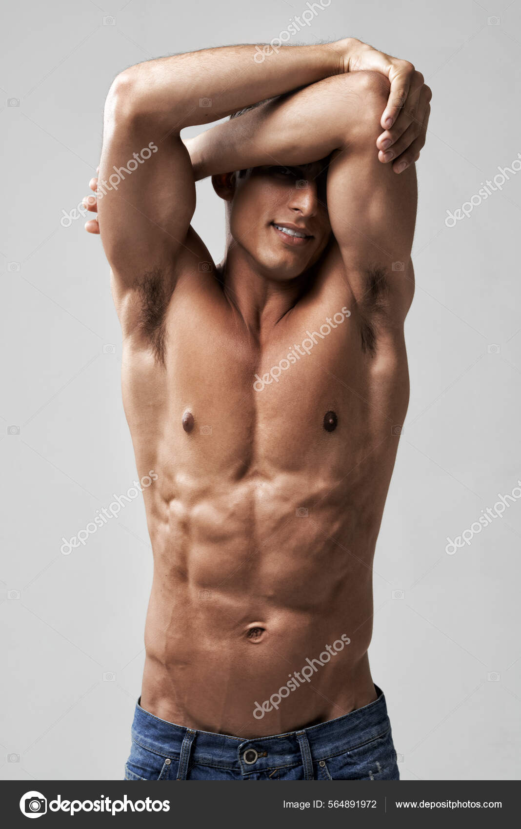 Showing off perfectly toned abs. A handsome young shirtless man posing