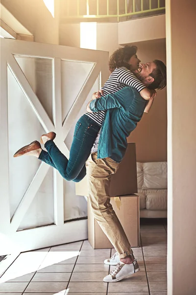 Conseguimos, querida. Tiro de um jovem casal feliz abraçando como eles se mudam para sua nova casa. — Fotografia de Stock
