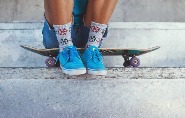 Nauč se bruslit. Vystřižen z mladé ženy sedí na svém skateboardu. — Stock fotografie