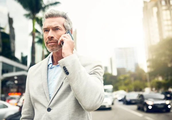 Si occupa di chiamate di lavoro tutto il giorno. Un uomo d'affari maturo che parla al cellulare in citta '.. — Foto Stock