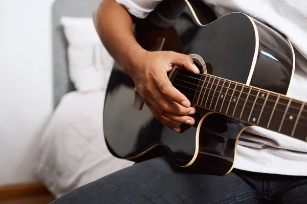 É uma ótima maneira de se expressar. Tiro de um jovem tocando guitarra em casa. — Fotografia de Stock